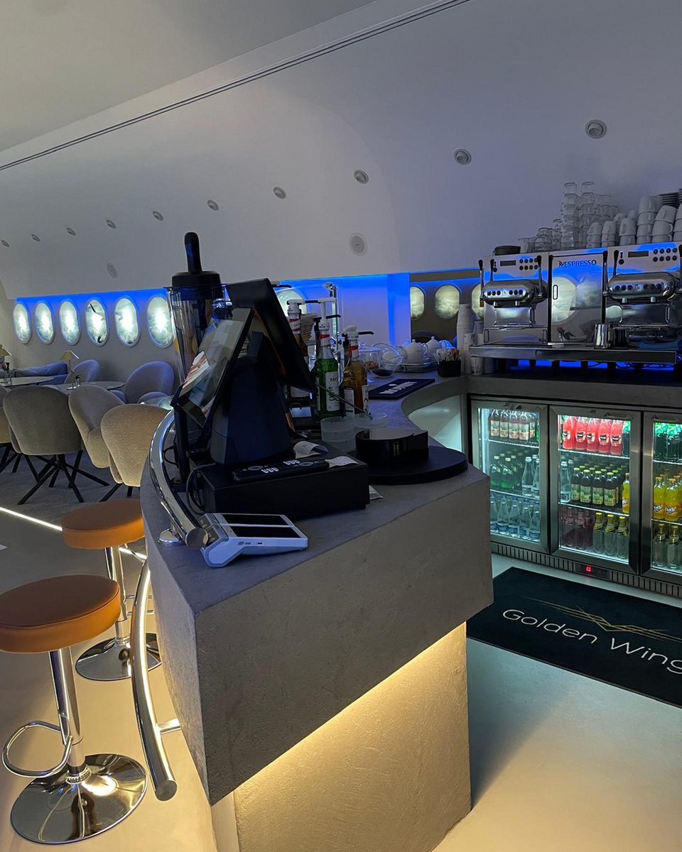 As built: the finished bar with a stone-topped counter, espresso machines and the Golden Wings name set into the face.