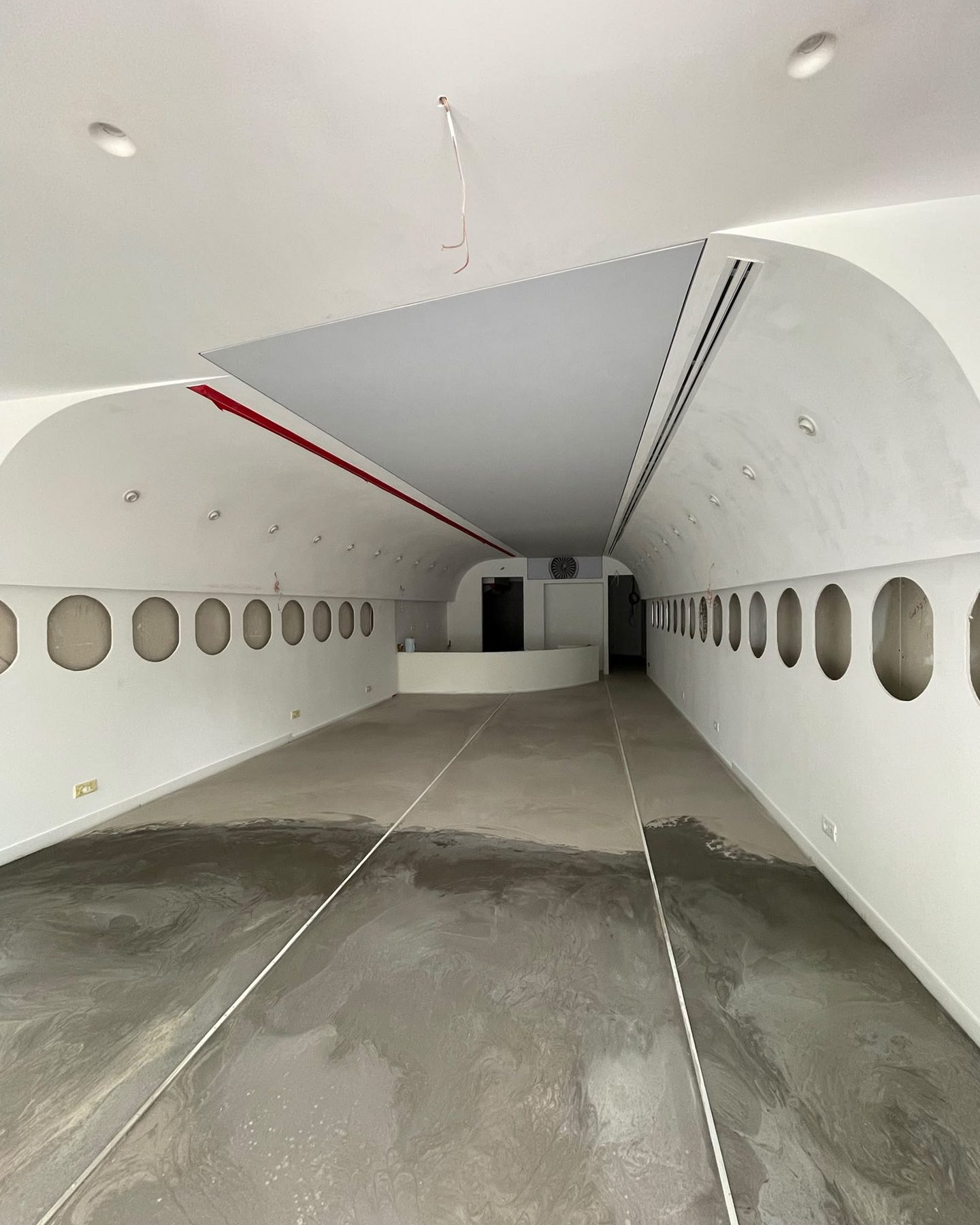 As found: the plastered concrete shell of the café with the ceiling arch formed, window openings cut and a bare concrete floor.