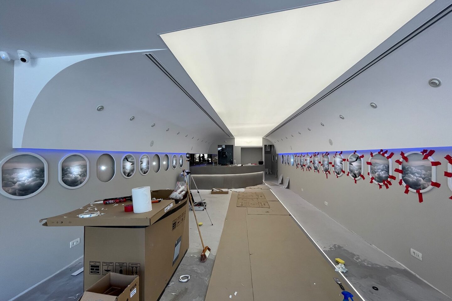 The illuminated ceiling panel switched on, protective cardboard on the floor and film over the window openings.