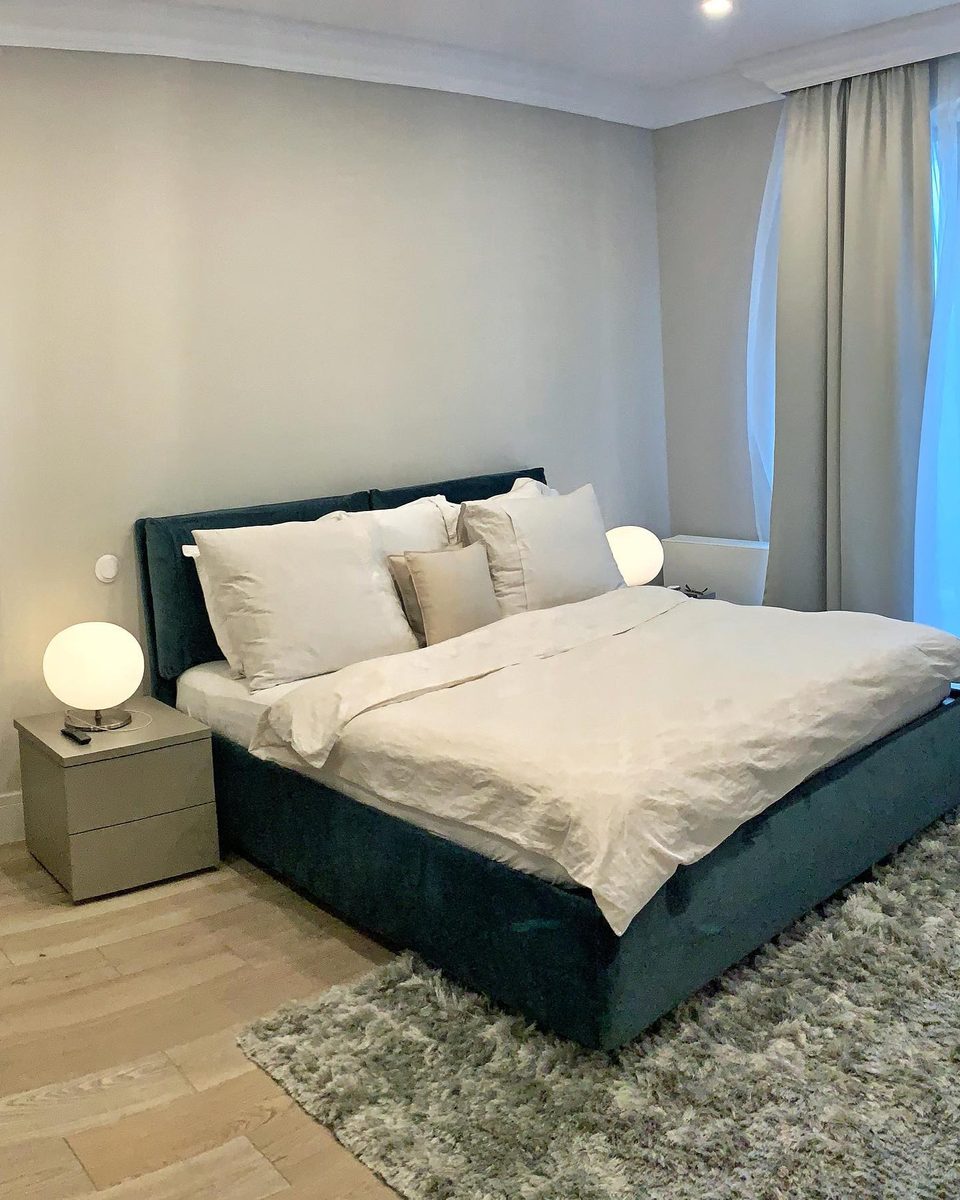 Bedroom: teal velvet upholstered bed with white linen and matching bedside cabinets.