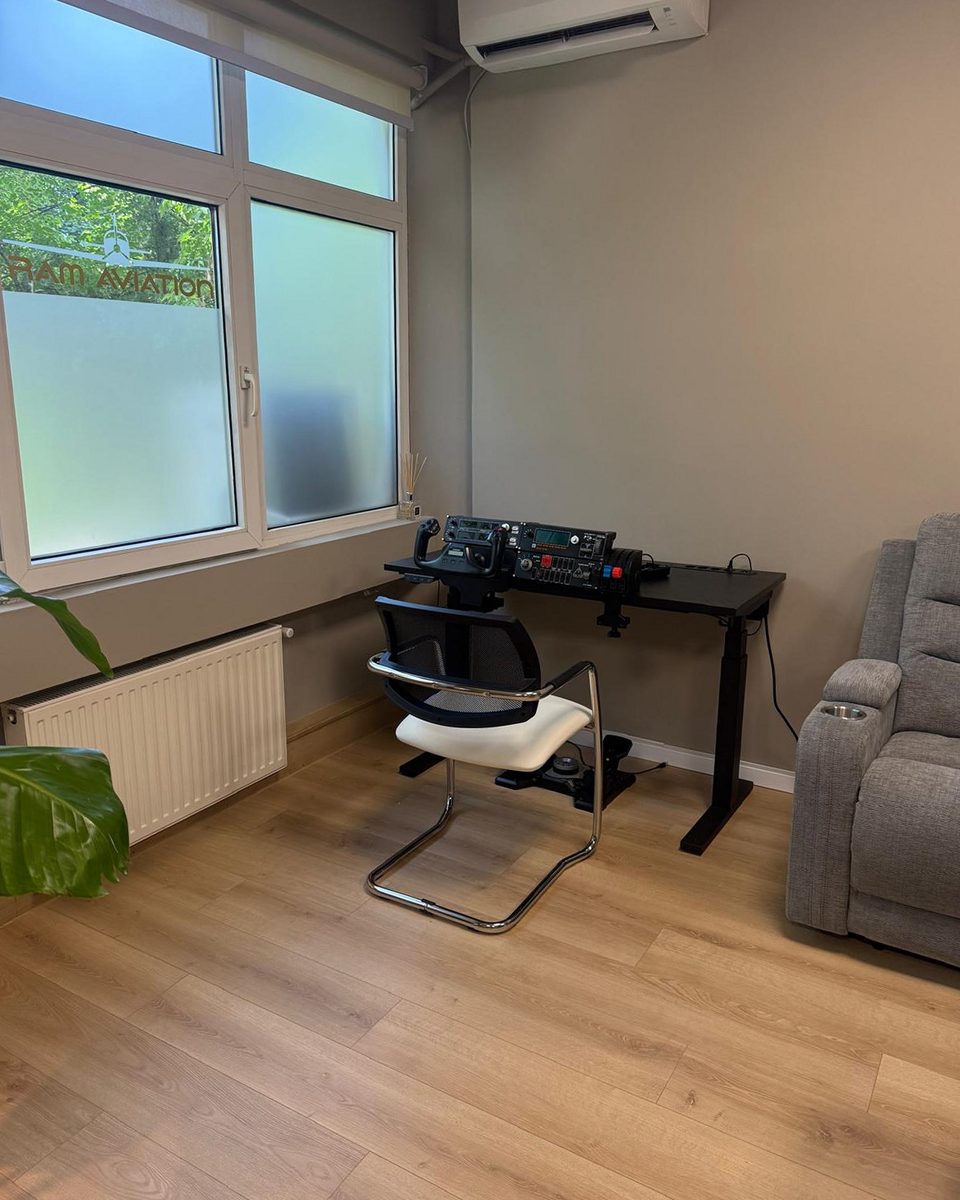 Corner workstation with a desk-mounted flight simulator yoke and throttle quadrant.